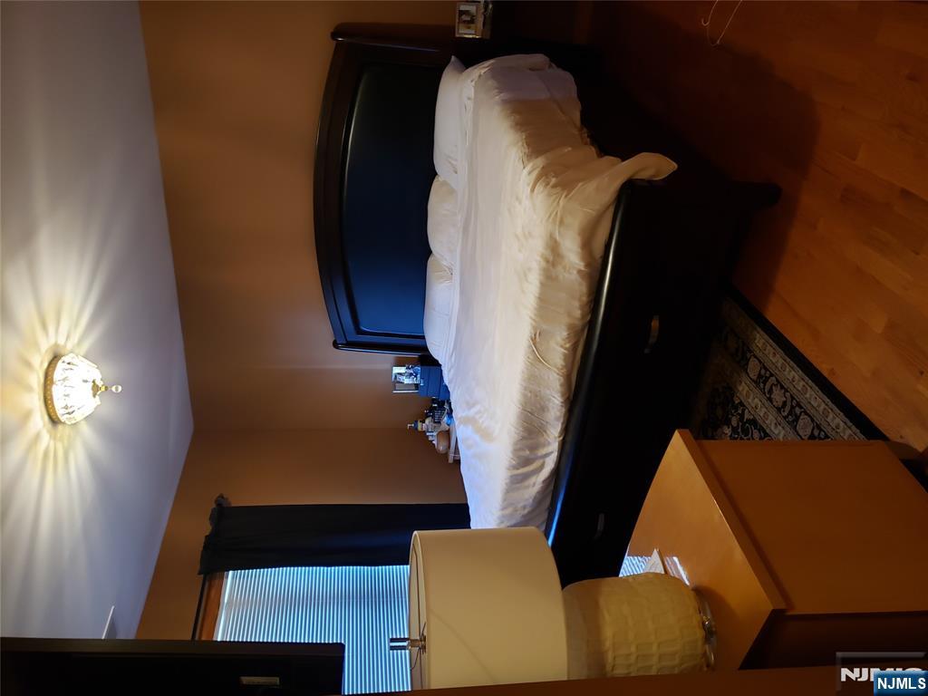 152 Miller Avenue, Unit 2 Elmwood Park, NJ 07407 - Photo 5 of 15 a bed sitting in a bedroom next to a lamp
