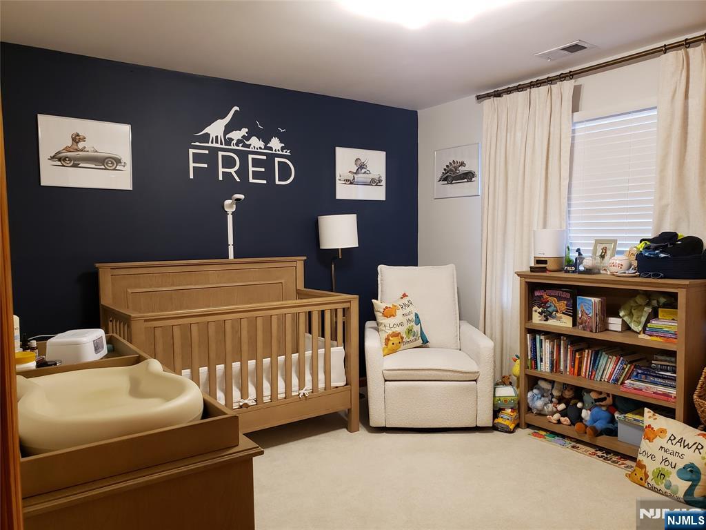 152 Miller Avenue, Unit 2 Elmwood Park, NJ 07407 - Photo 7 of 15 a bedroom with furniture and a book shelf