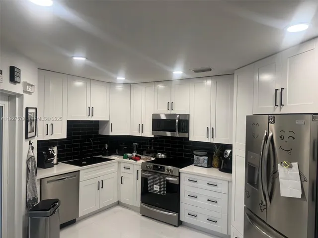 a kitchen with stainless steel appliances a refrigerator stove and microwave