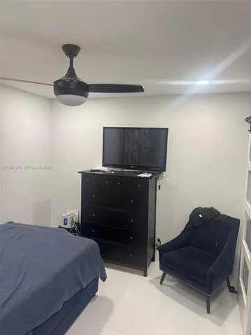 a bedroom with a bed and a chandelier fan