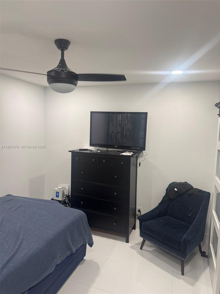 1131 Southwest 110th Avenue Pembroke Pines, FL 33025 - Photo 8 of 9 a bedroom with a bed and a chandelier fan