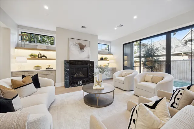 a living room with fireplace furniture and a large window