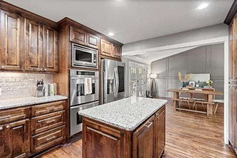 a bedroom with a large bed and a flat tv screen on dresser