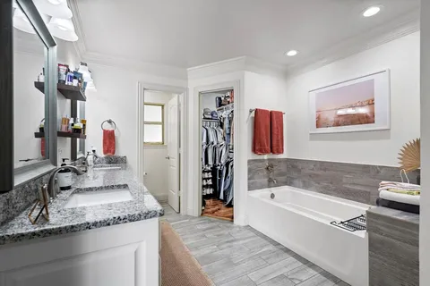 a bathroom with a granite countertop sink a toilet and a mirror