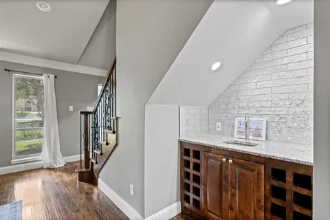 a kitchen with stainless steel appliances granite countertop a stove a refrigerator a sink dishwasher a dining table and chairs with wooden floor