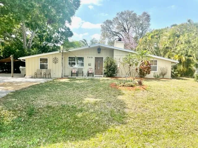 a front view of a house with a yard and trees