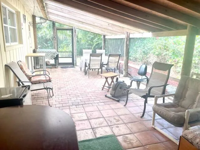 a living room with couches and a dining table with garden view