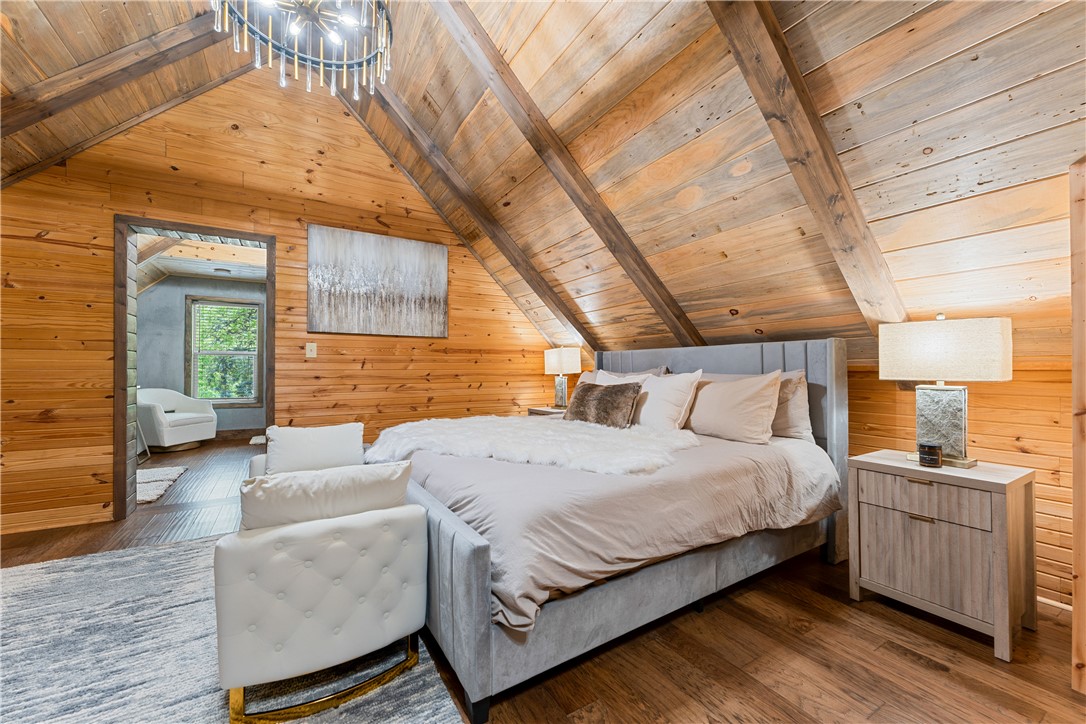 3931 Zack Road Marshall, AR 72650 - Photo 17 of 56 Bedroom with wood walls, wood-type flooring, a wooden ceiling with exposed beams, and a chandelier