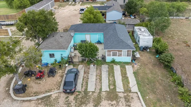 a front view of a house with a garden and cars parked