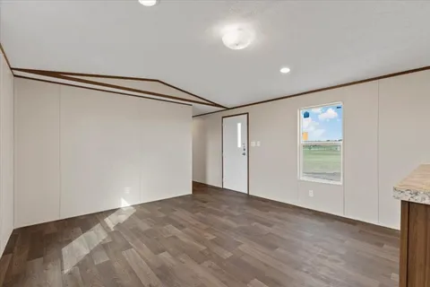 a view of a big room with wooden floor and windows