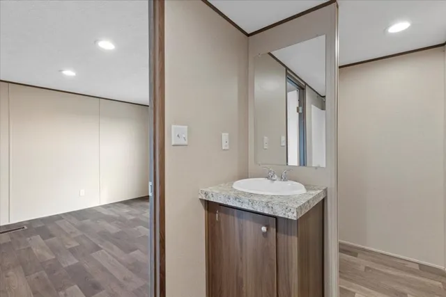 a white toilet sitting next to a white sink and vanity