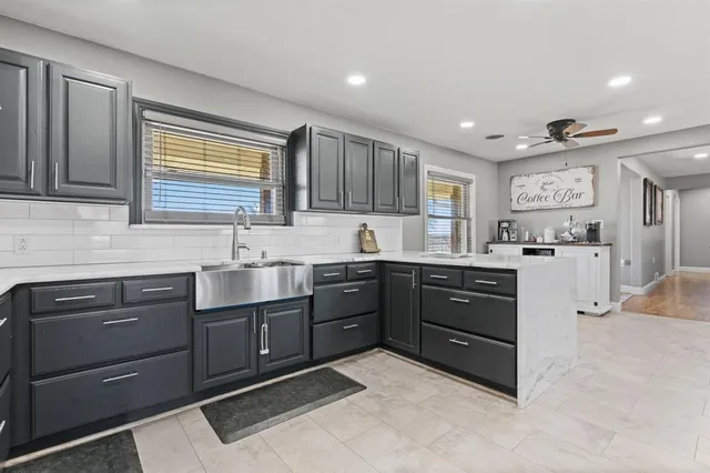 a kitchen with granite countertop a sink cabinets and stainless steel appliances
