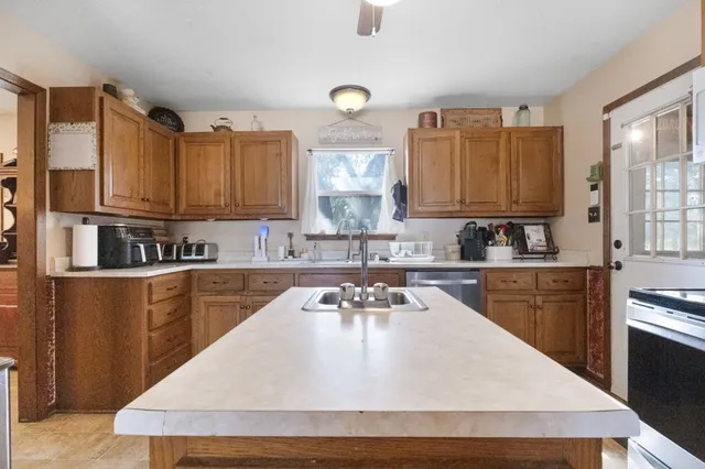 a kitchen with kitchen island granite countertop a sink stove and refrigerator