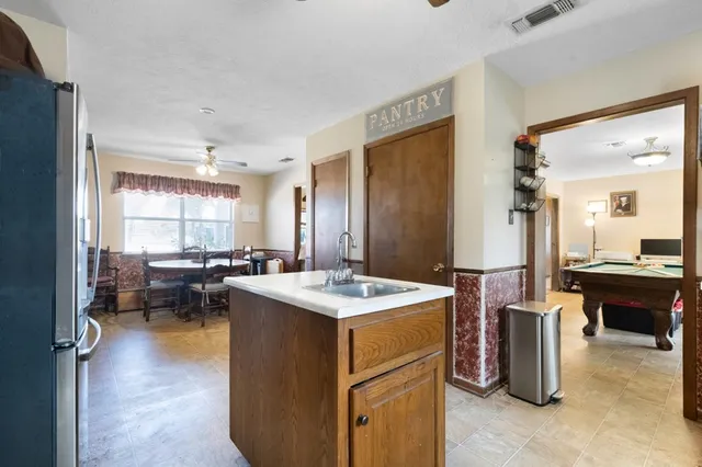 a view of kitchen island with stainless steel appliances kitchen island wooden floor and living room view