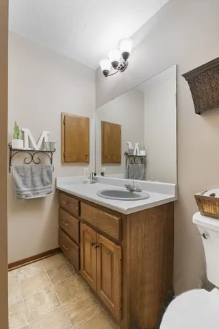 a bathroom with a granite countertop sink a toilet and mirror