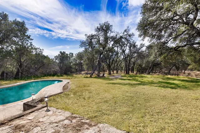 a view of a swimming pool with a yard and sitting area