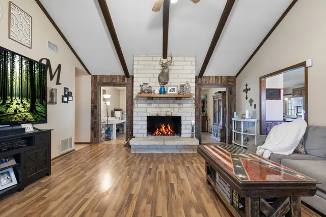 a living room with furniture a fireplace and a flat screen tv
