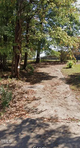 a view of dirt yard with a tree