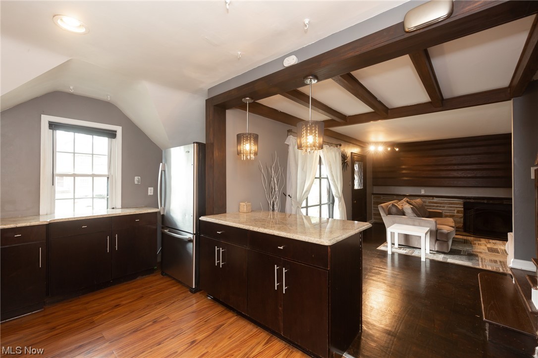 3786 Berkeley Road Cleveland Heights, OH 44118 - Photo 8 of 29 Kitchen with a fireplace, hanging light fixtures, stainless steel refrigerator, a notable chandelier, and light hardwood / wood-style flooring