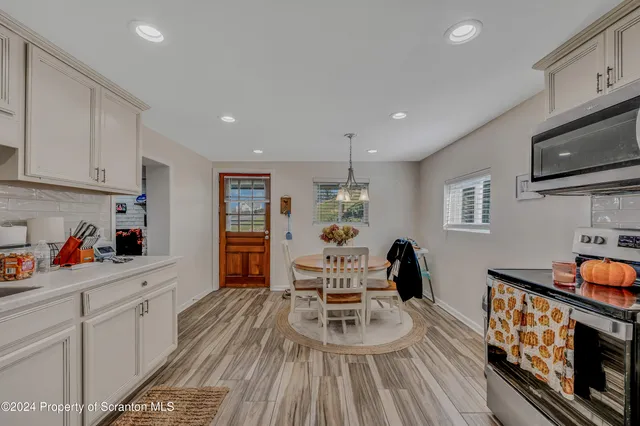 a living room with furniture a flat screen tv and kitchen view