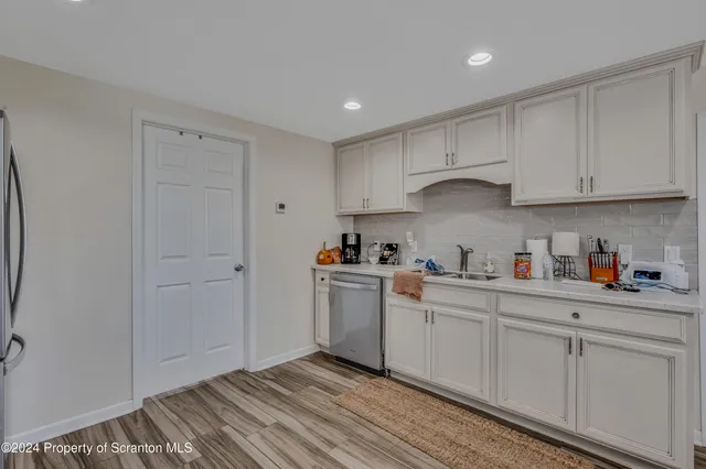 a kitchen with white cabinets and white appliances