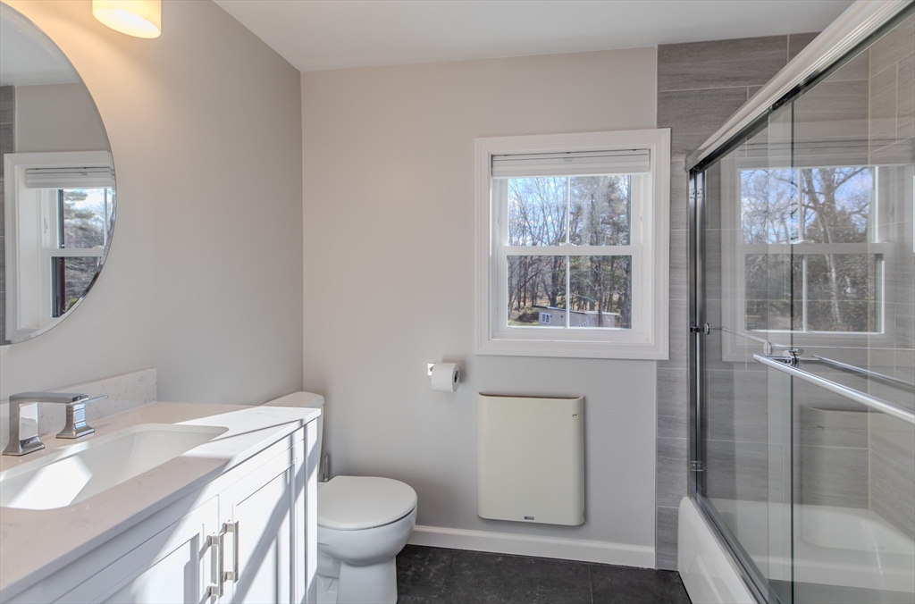265 Stanley Street Amherst, MA 01002 - Photo 17 of 35 a bathroom with a granite countertop toilet a sink and a mirror