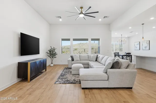 a large living room with stainless steel appliances kitchen island a flat screen tv and a couch