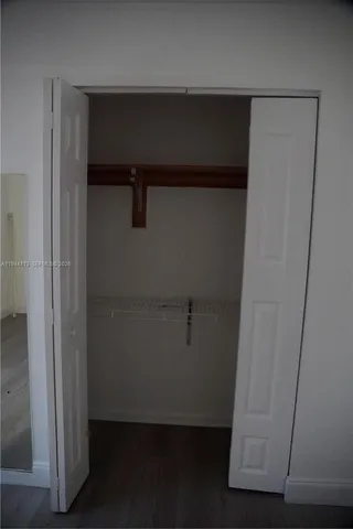 an empty room with closet and wooden floor