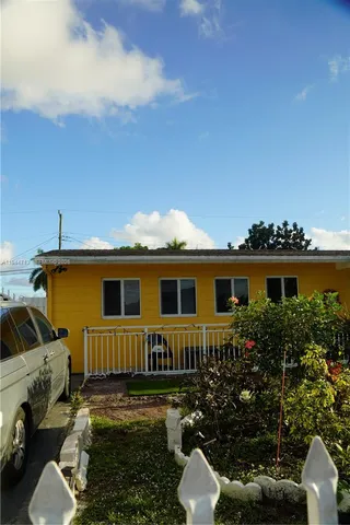 a view of a house with backyard sitting area and garden