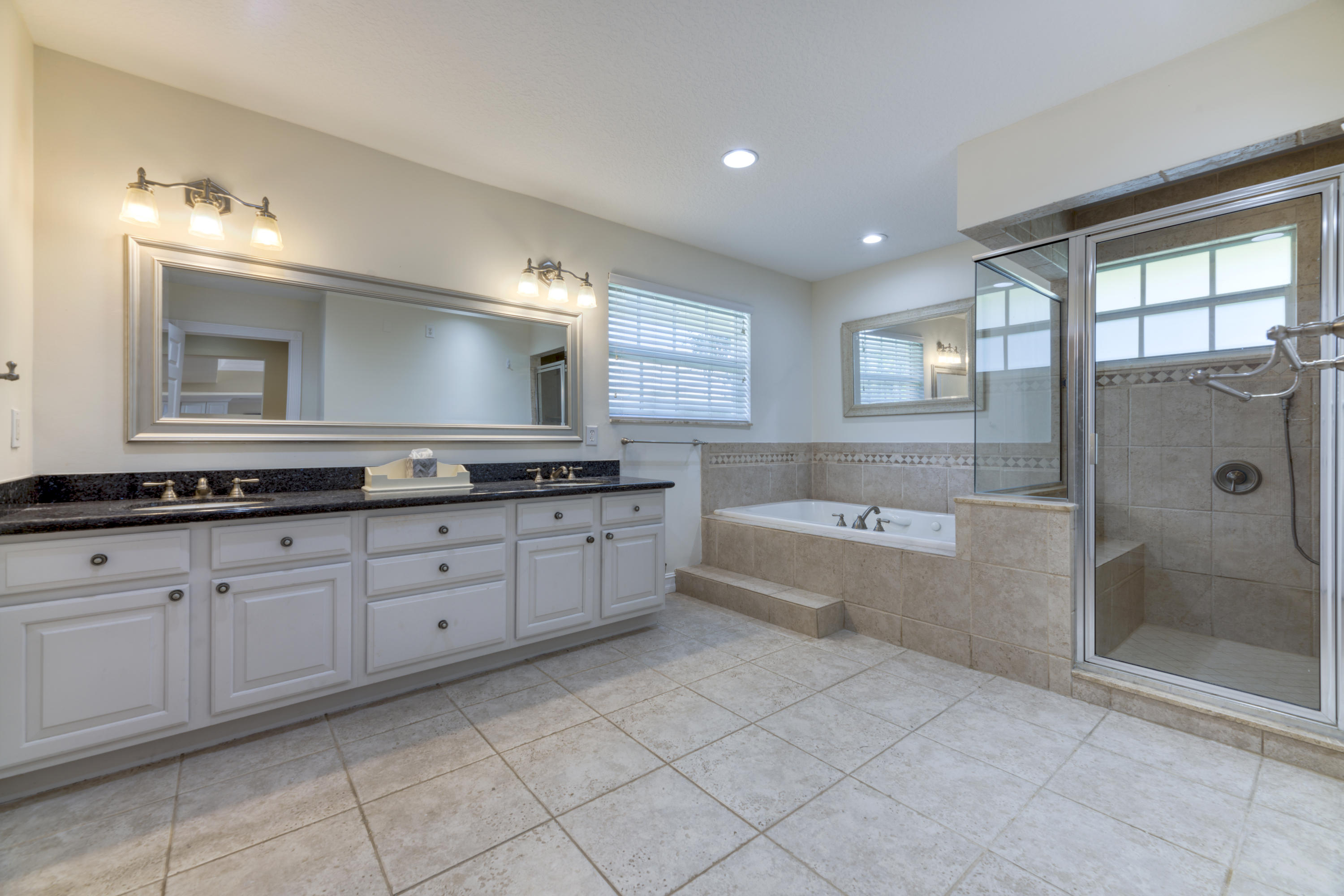 12920 Barrow Road North Palm Beach, FL 33408 - Photo 21 of 32 a bathroom with a bathtub a mirror a double vanity sink and vanity