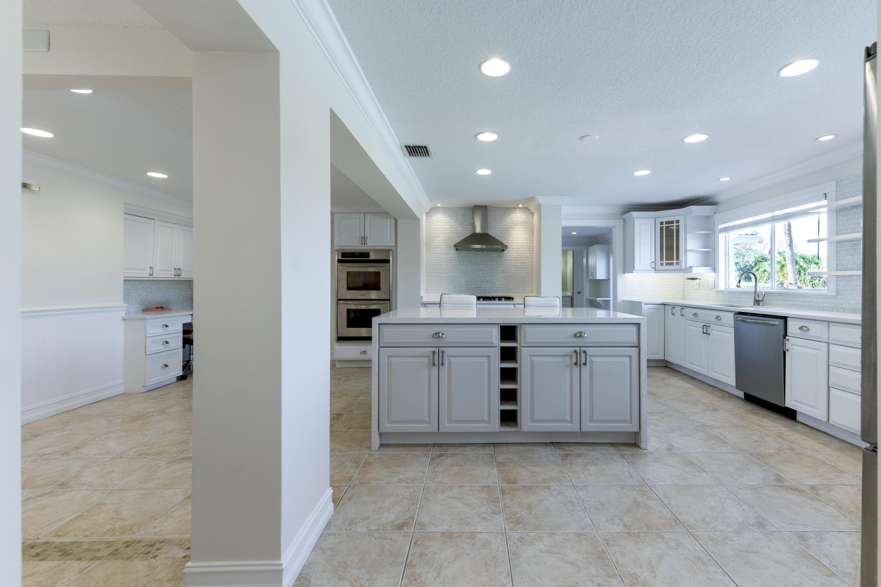 12920 Barrow Road North Palm Beach, FL 33408 - Photo 9 of 32 a kitchen with stainless steel appliances kitchen island granite countertop a sink and cabinets