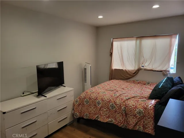 a bedroom with a bed and a flat screen tv
