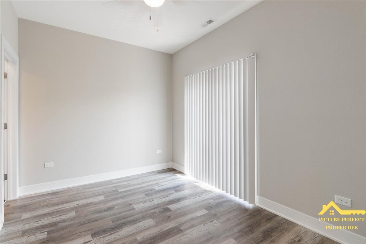 6337 South Ellis Avenue, Unit 3 Chicago, IL 60637 - Photo 8 of 12 wooden floor in an empty room with a window