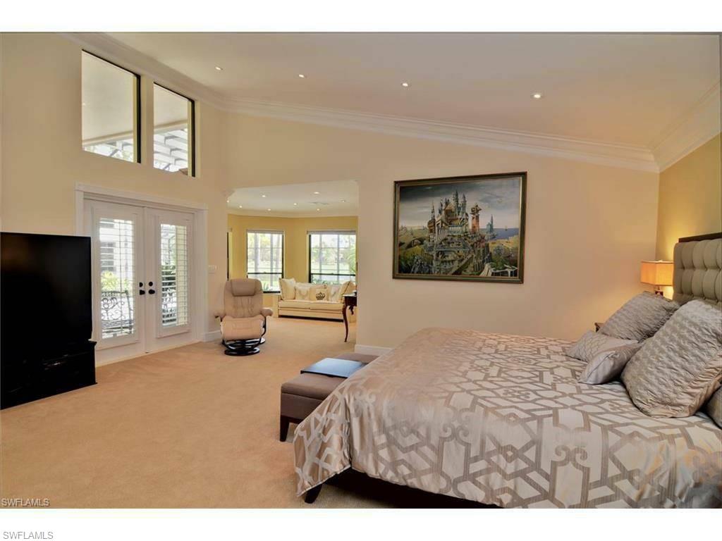 12902 Coco Plum Lane Naples, FL 34119 - Photo 22 of 23 a bedroom with a large bed and a couch