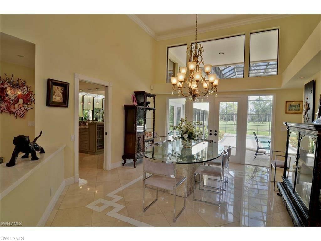 12902 Coco Plum Lane Naples, FL 34119 - Photo 6 of 23 a view of a dining room with furniture a chandelier and large window