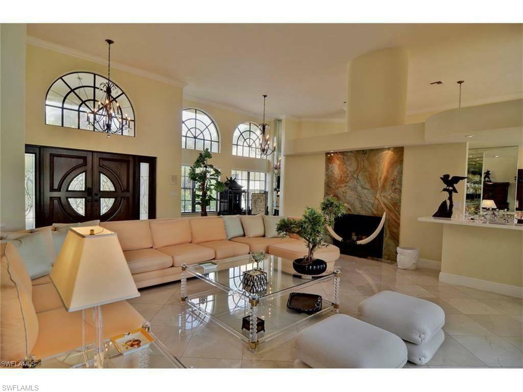 12902 Coco Plum Lane Naples, FL 34119 - Photo 9 of 23 a living room with furniture a chandelier and kitchen view