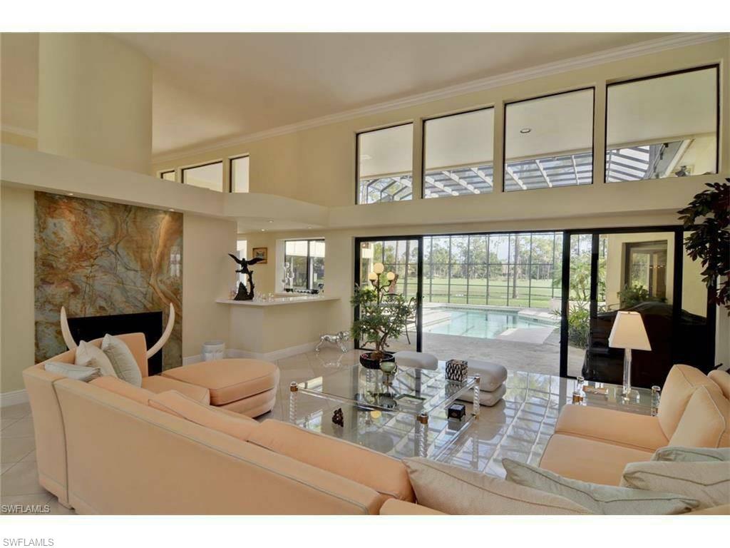 12902 Coco Plum Lane Naples, FL 34119 - Photo 10 of 23 a living room with furniture large windows and wooden floor