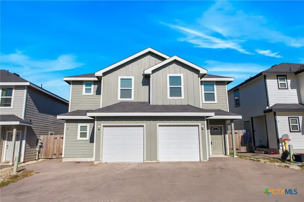 a front view of a house with yard and garage