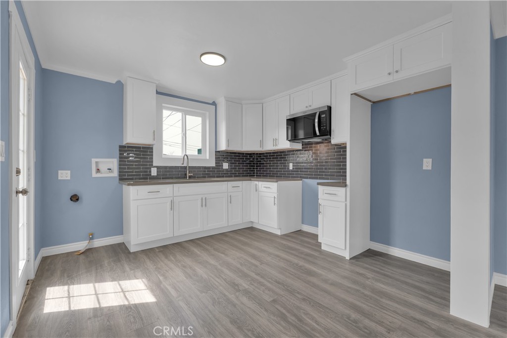 34945 Ave B Yucaipa, CA 92399 - Photo 14 of 69 a large kitchen with cabinets and wooden floor