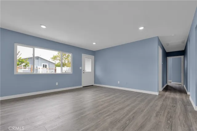 a kitchen with stainless steel appliances granite countertop a refrigerator a sink dishwasher and white cabinets with wooden floor