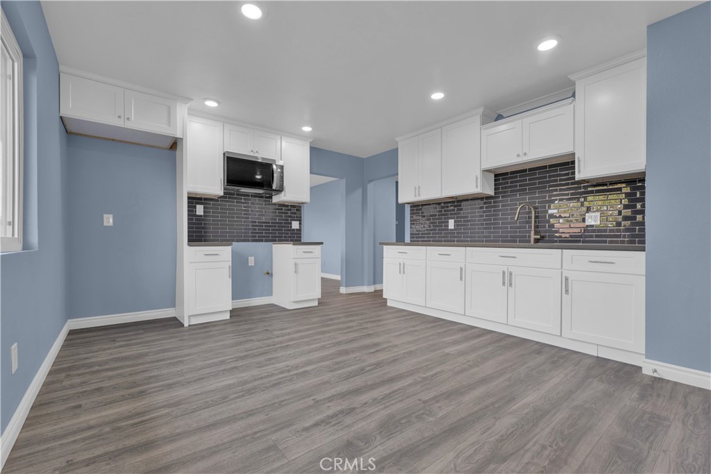34945 Ave B Yucaipa, CA 92399 - Photo 38 of 69 a large kitchen with stainless steel appliances granite countertop a wooden floors and white cabinets
