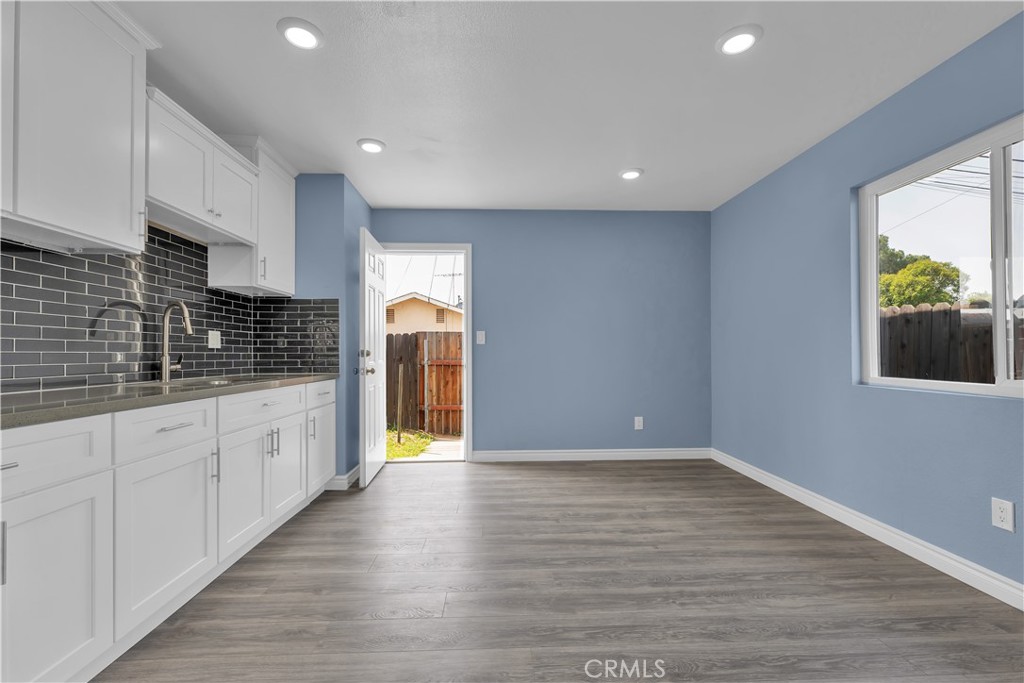 34945 Ave B Yucaipa, CA 92399 - Photo 40 of 69 a kitchen with stainless steel appliances granite countertop a refrigerator a sink dishwasher and white cabinets with wooden floor