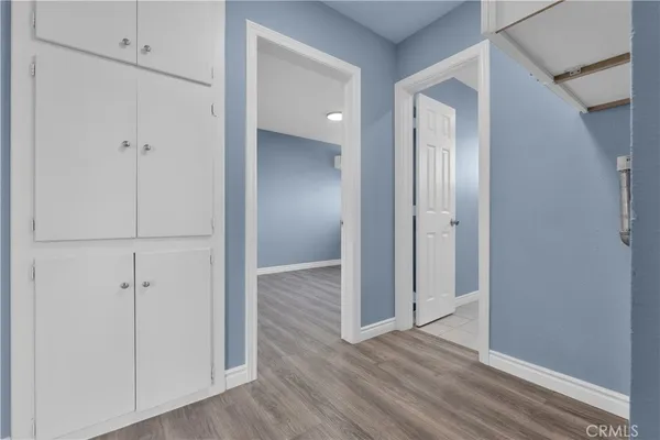 a view of an empty room with wooden floor and windows