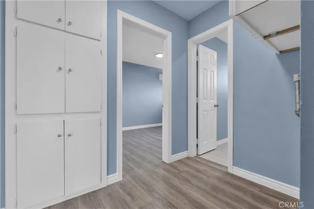 a view of an empty room with wooden floor and windows