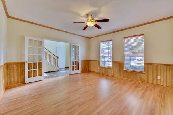 a view of an empty room with a window and wooden floor