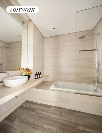 a bathroom with a tub a sink and a large mirror