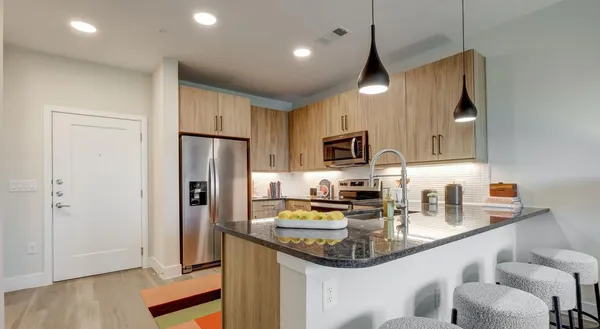 a kitchen with stainless steel appliances granite countertop a sink refrigerator and microwave