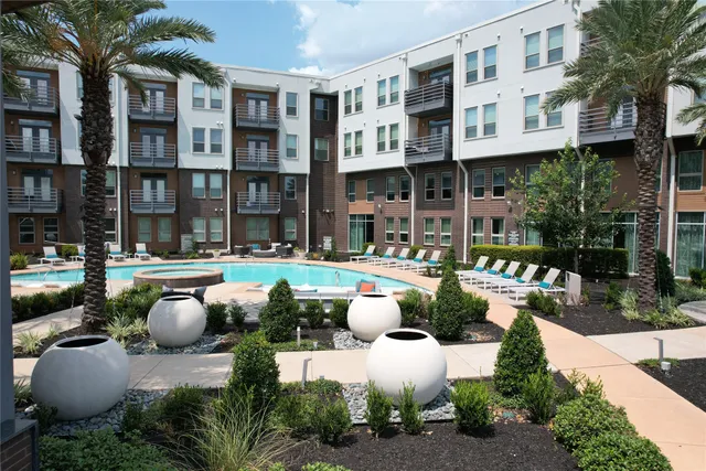 a view of a patio with couches table and chairs potted plants and palm trees