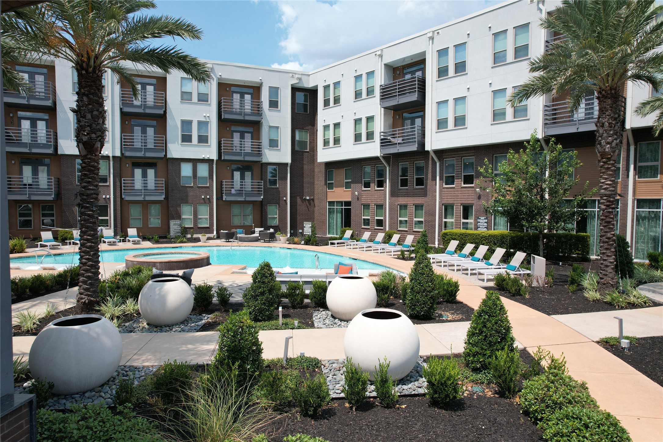 23233 Western Centre Drive, Unit A1 Katy, TX 77494 - Photo 2 of 14 a view of a patio with couches table and chairs potted plants and palm trees