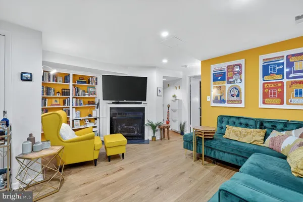 a living room with furniture and a flat screen tv with wooden floor